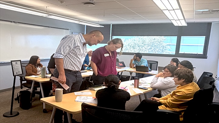 A group of educators working together in small groups during an interactive workshop.