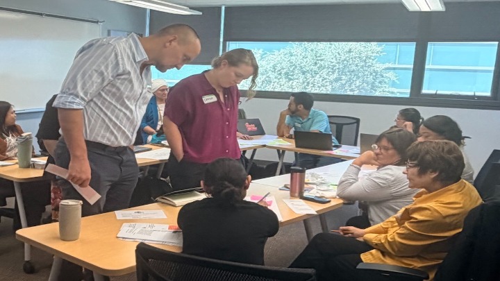 A group of educators working together in small groups during an interactive workshop.